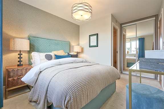 A bedroom with a large bed and a mirror on the wall.