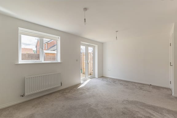 A room with a carpeted floor and a window.