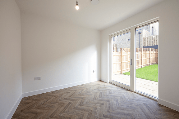 A room with a wooden floor and a sliding glass door.