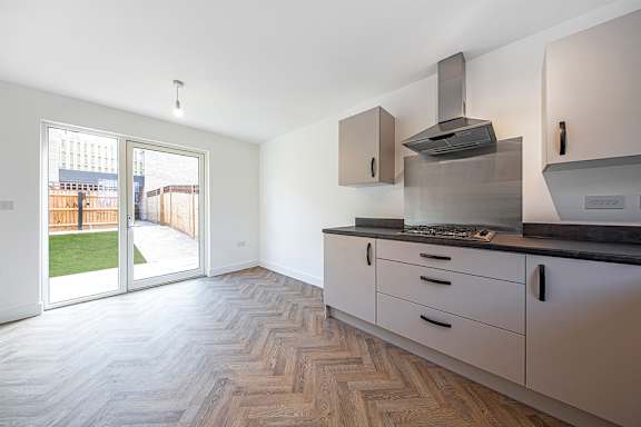 A kitchen with a stove top oven and a window.