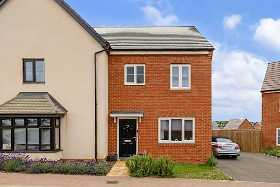 A house with a red brick wall and a black door.