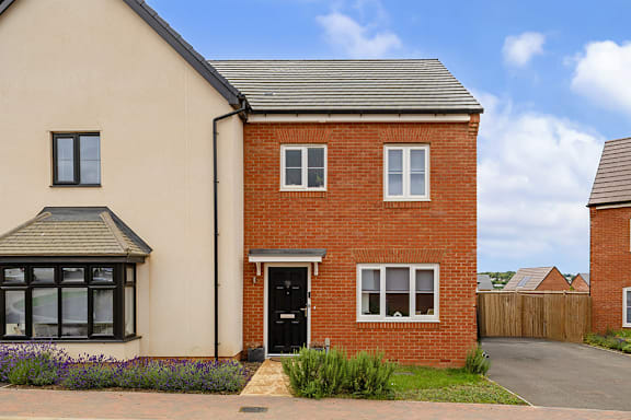 A red brick house with a black door and windows.