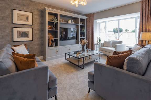 A living room with grey couches and a glass coffee table.
