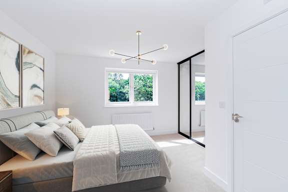 A bedroom with a large bed and a chandelier.