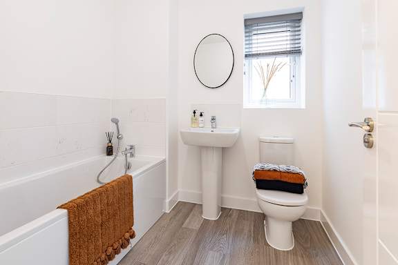 A white bathroom with a toilet, sink, and bathtub.