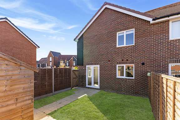 A red brick house with a white door and windows.