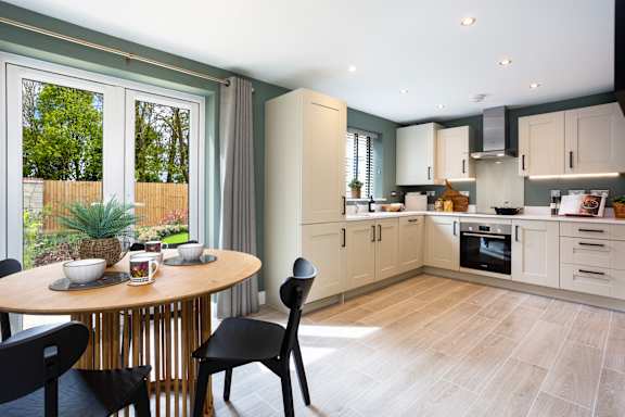 A modern kitchen with a round table and chairs.