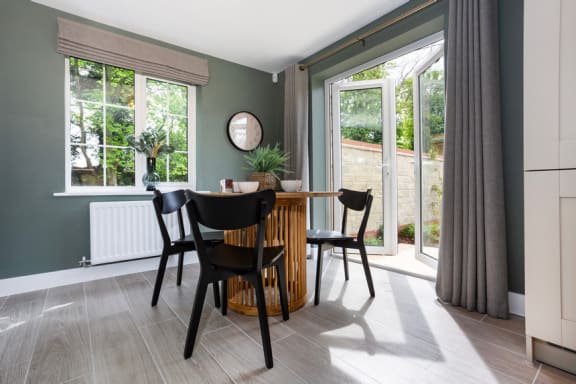 a dining room with a table and chairs and a window