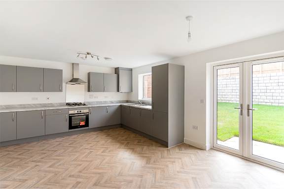 A kitchen with a wooden floor and a white ceiling.