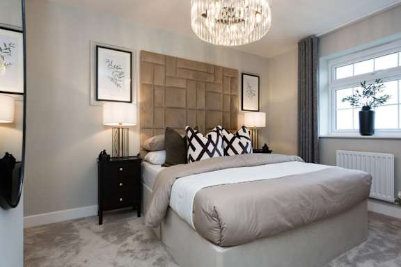 A bedroom with a large bed and a chandelier.