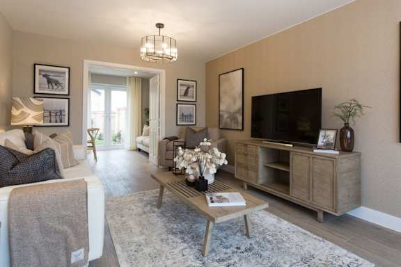A living room with a sofa, a coffee table, and a television.