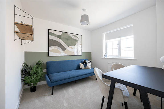A blue couch sits in a room with a table and chairs.