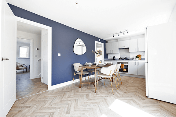 A kitchen with a dining table and chairs in the middle of the room.