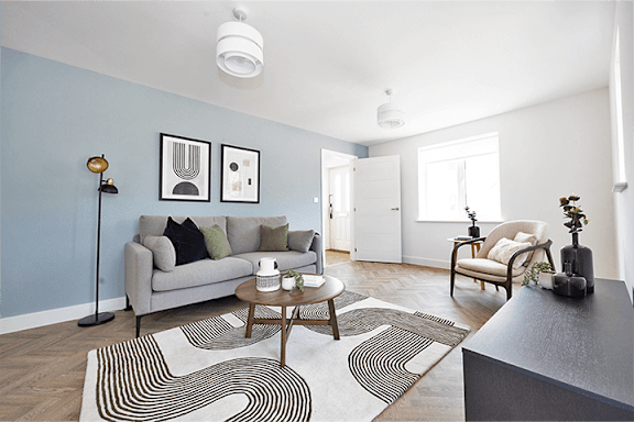 A living room with a grey couch, a coffee table, and a striped rug.