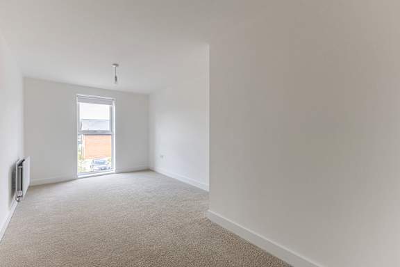 A room with a carpeted floor and a window.