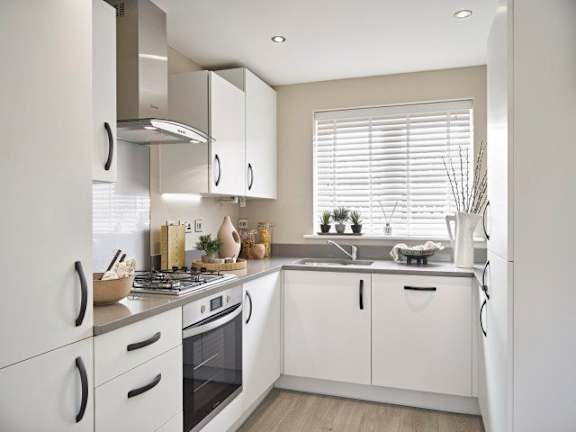 A modern kitchen with white cabinets and appliances.