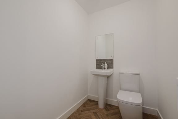 A white sink and toilet in a small bathroom.