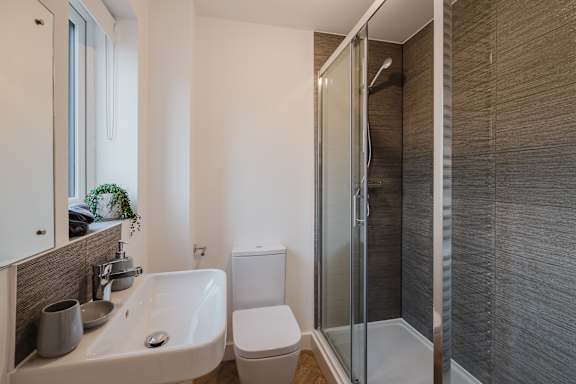 A modern bathroom with a white sink and toilet.