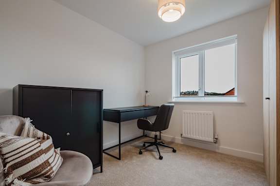 A room with a desk and chair in it.