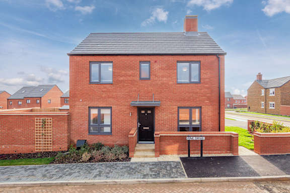 A red brick house with a black front door and windows.
