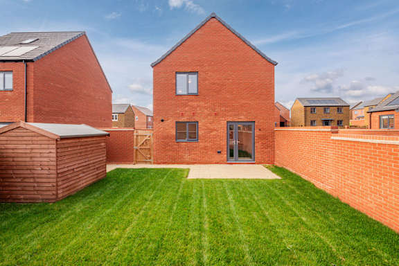 A red brick house with a green lawn in front.