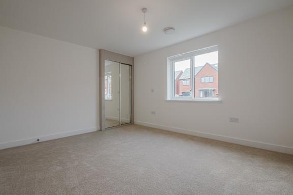 A room with a window showing a red house outside.