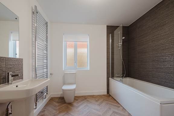 A white bathroom with a toilet, sink, and bathtub.