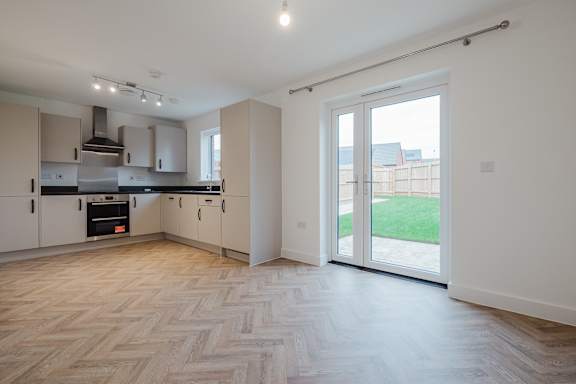 A spacious kitchen with a herringbone parquet floor.