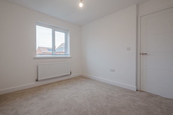 A room with a window and a radiator on the wall.