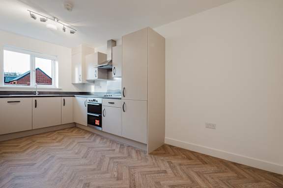 A kitchen with a stove top oven and a window.