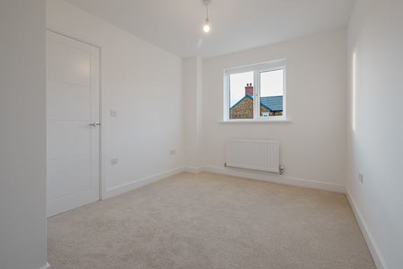A room with a window showing a house on the other side.