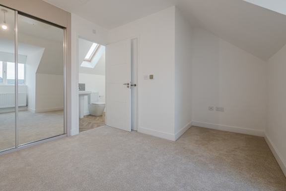 A room with white walls and carpeted floor with a glass door.
