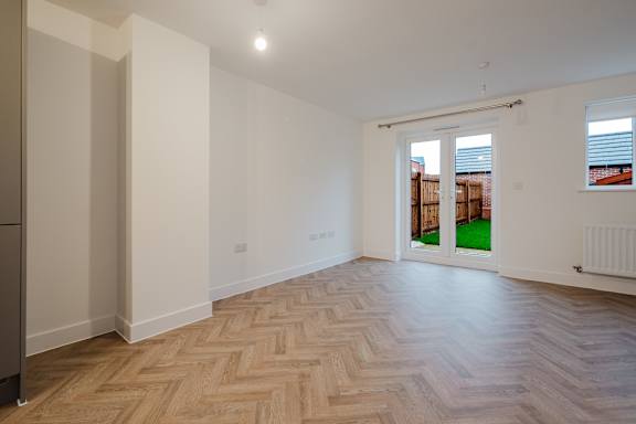 A room with wooden flooring and white walls.