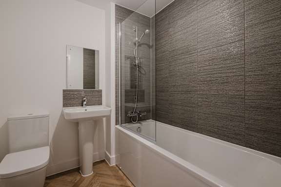 A bathroom with a toilet, sink, and shower.