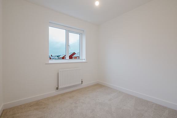 A room with a window and a radiator on the wall.