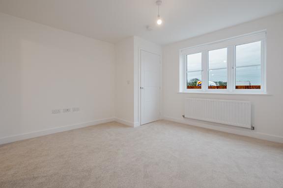 A white room with a window and a radiator.