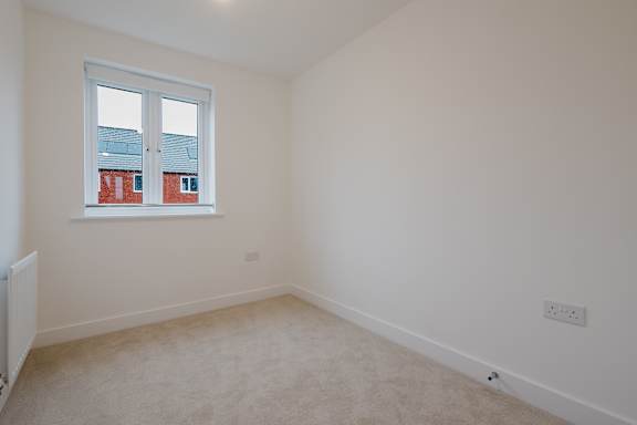 A room with a window and a radiator on the wall.