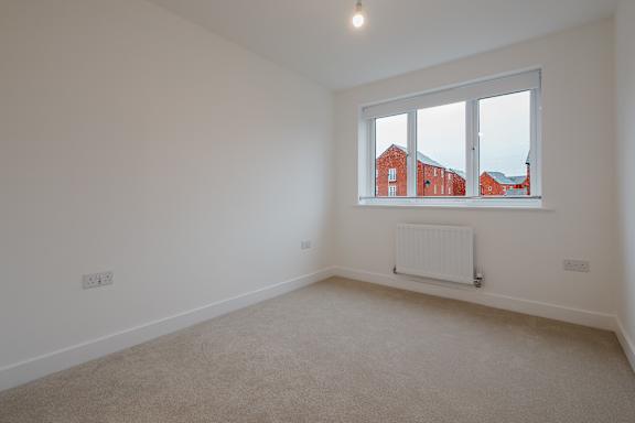 A room with a window and a radiator on the wall.