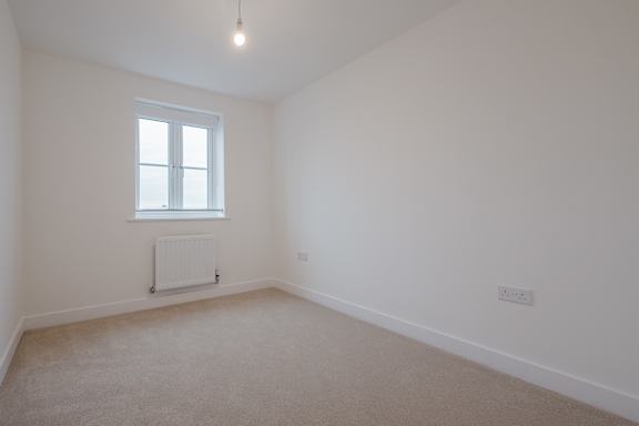 A room with a window and a radiator on the wall.