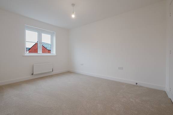 A room with a window and a radiator on the floor.