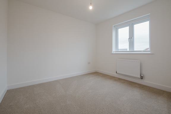 A room with a window and a radiator on the wall.