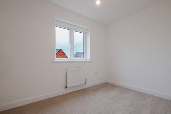 A room with a window and a radiator on the wall.