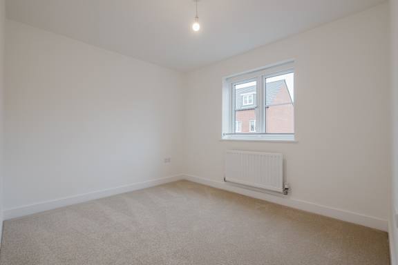 A room with a window and a radiator on the floor.