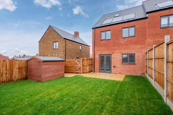 A red brick house with a green lawn in front.