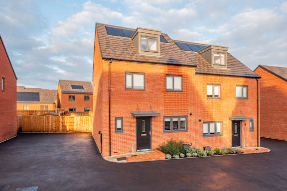 A red brick house with a black door and windows.