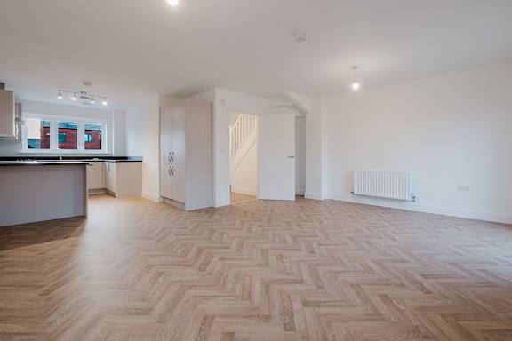 A room with a wooden floor and white walls.