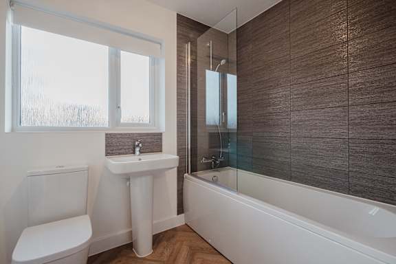 A white toilet sits next to a sink in a bathroom.