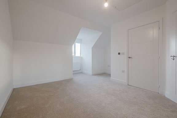 A room with a carpeted floor and a skylight.
