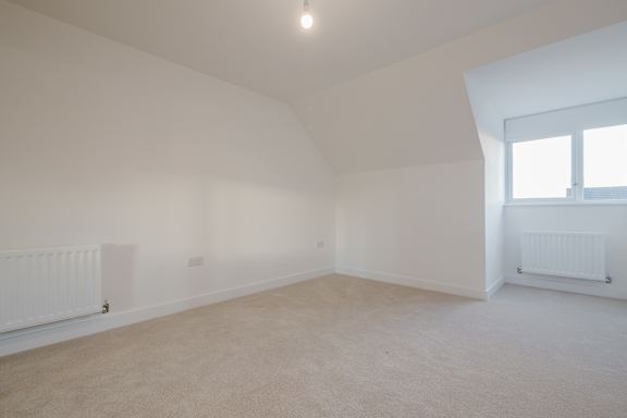 A white room with a window and two radiators.