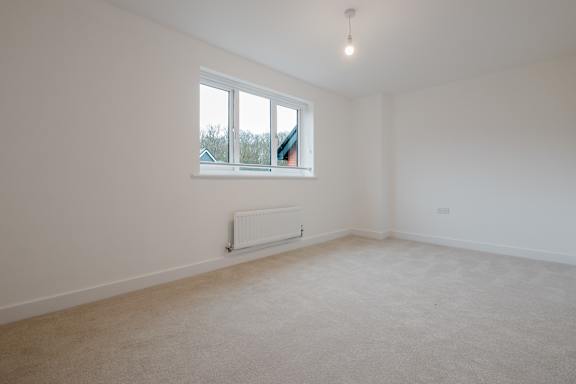 A room with a window and a radiator on the wall.